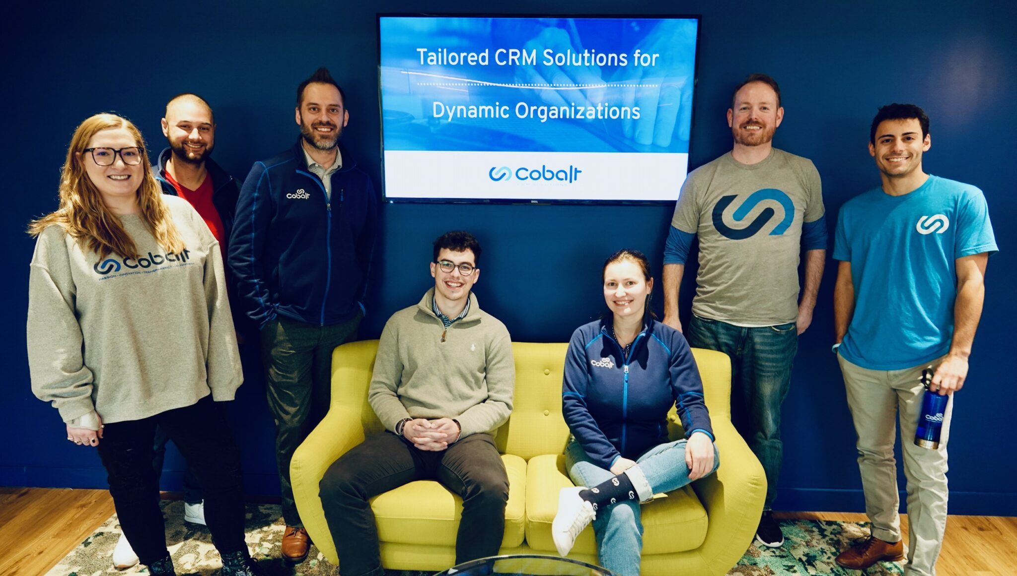 Some of Cobalt's certification management software experts in a group photo of the Cobalt lobby.